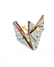 Small wooden origami fox ornament featuring white, green, and blue plum blossoms on a gray background with metallic gold details.