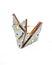 Small wooden origami fox ornament featuring white, green, and blue plum blossoms on a gray background with metallic gold details.