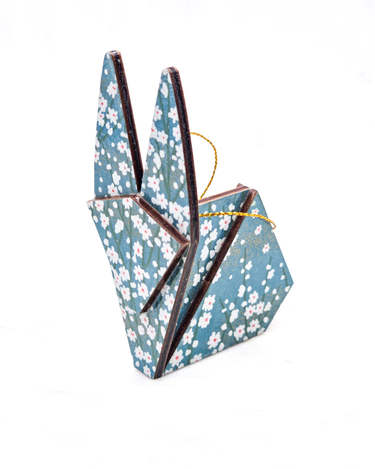 Large wooden origami rabbit ornament featuring small white flower bushes over a blue background with metallic gold details.