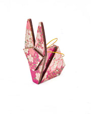 
Small wooden origami rabbit ornament featuring pink and white cherry blossoms on a pearlescent pink background with metallic gold details.