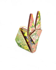 Small wooden origami rabbit ornament featuring small white, green, and orange flowers on a gray and green background with metallic gold details.