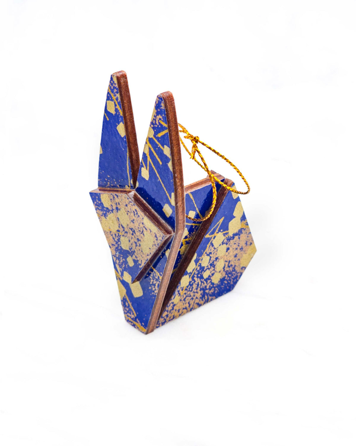 Small wooden origami rabbit ornament featuring scattered metallic gold geometric shapes and fine gold lines on a blue background.