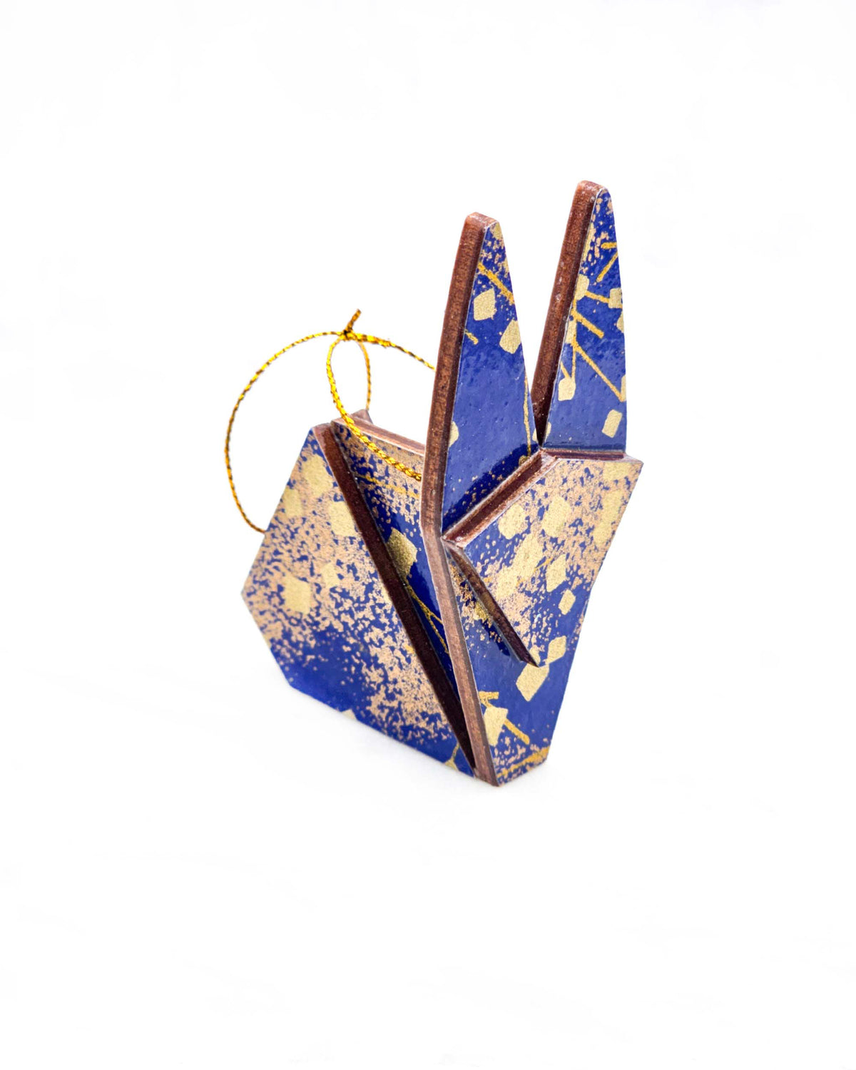 Small wooden origami rabbit ornament featuring scattered metallic gold geometric shapes and fine gold lines on a blue background.