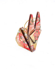 Small wooden origami rabbit ornament featuring red and purple floral hand fans and gold floral ribbons on an orange gradient background covered in small white plum blossoms with metallic gold details.