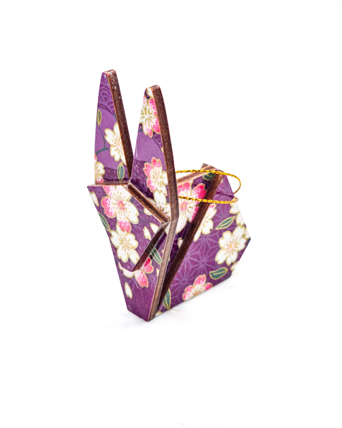 Small wooden origami rabbit ornament featuring pink and white cherry blossoms on a purple background with light asanoha (hemp leaf) and seigaiha (wave crest) silhouettes and metallic gold details.
