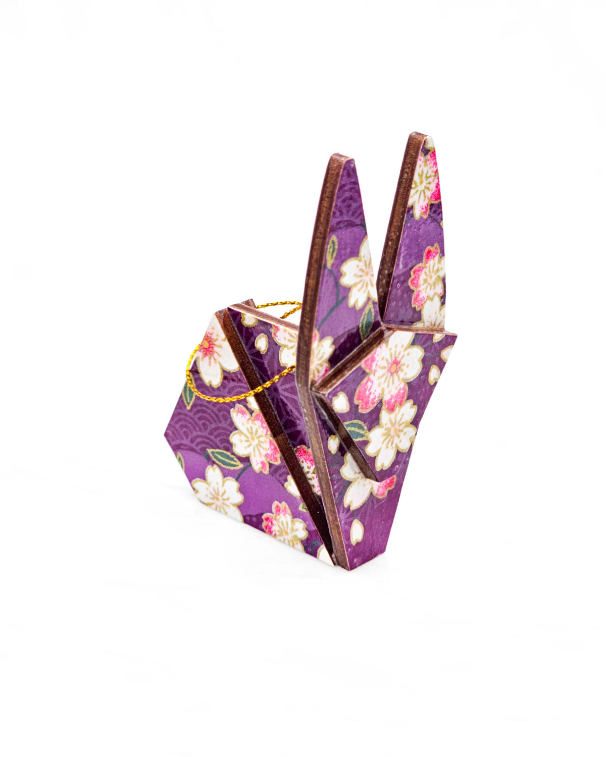 Small wooden origami rabbit ornament featuring pink and white cherry blossoms on a purple background with light asanoha (hemp leaf) and seigaiha (wave crest) silhouettes and metallic gold details.