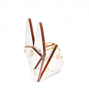 Small wooden origami rabbit ornament featuring gold and white cherry blossoms on a pearlescent white background with small metallic silver specks.
