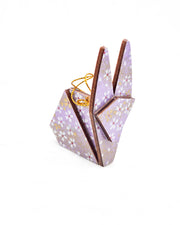 Small wooden origami rabbit ornament featuring small white and gold cherry blossoms on a purple background with metallic gold details.