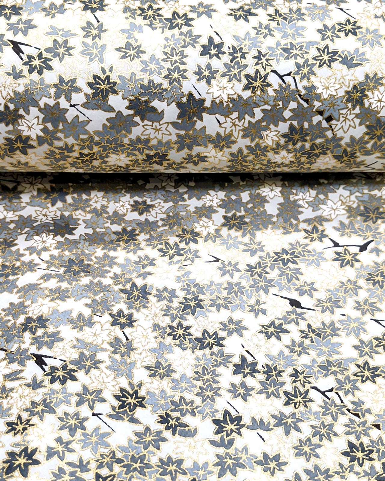 Japanese chiyogami featuring gray and white maples leaves on a light gray background with metallic gold accents.