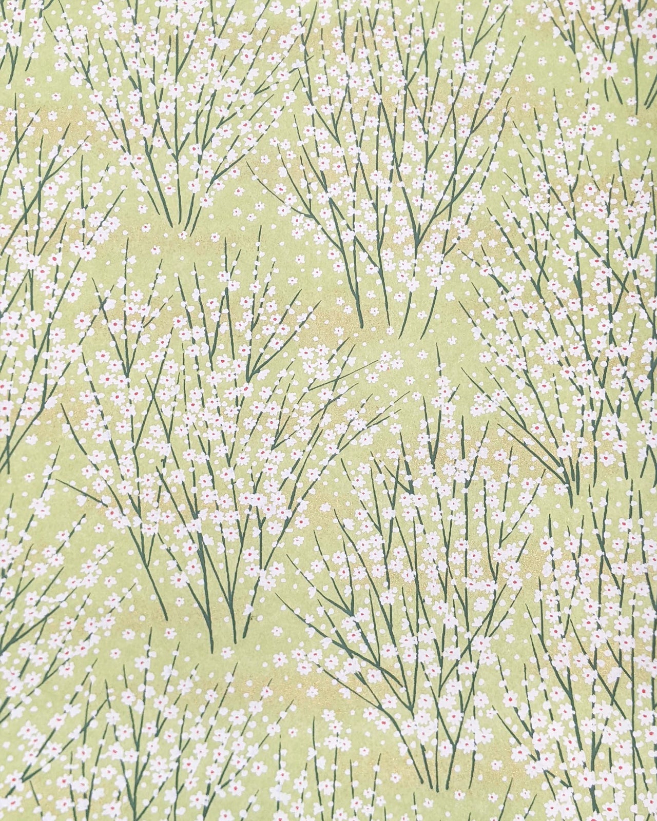 Japanese chiyogami paper featuring small white flower bushes over a yellow green background with metallic gold accents.
