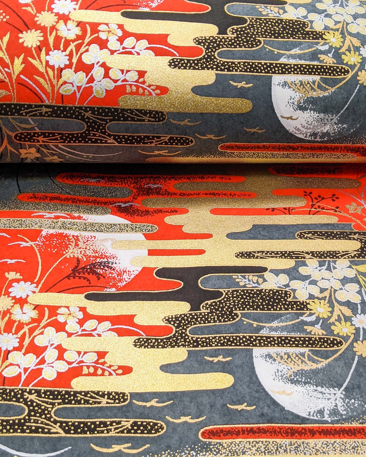 Japanese chiyogami paper featuring full moons, flowers, and flying birds on a red and gray background with metallic silver and gold accents.
