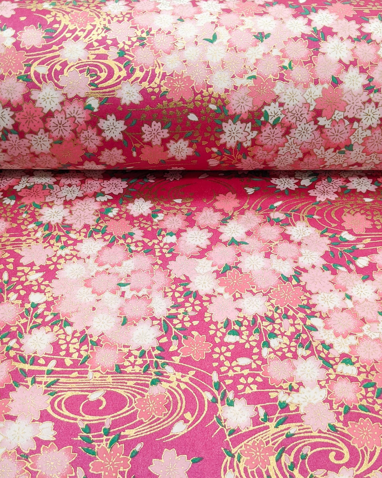 Japanese chiyogami paper featuring pink and white cherry blossoms on a pearlescent pink background with metallic gold accents.