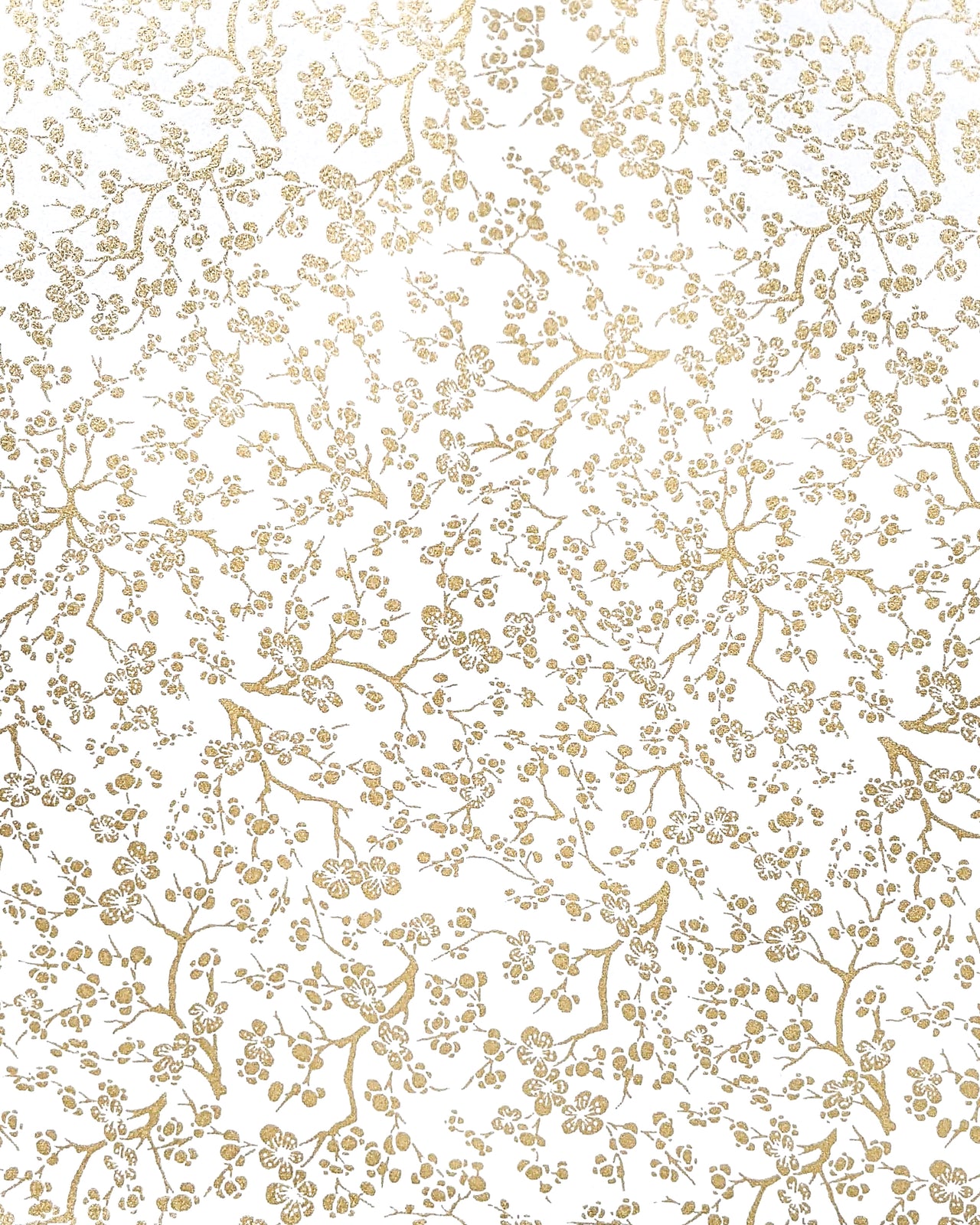 Japanese chiyogami paper featuring small metallic gold plum blossom branches on a white background.