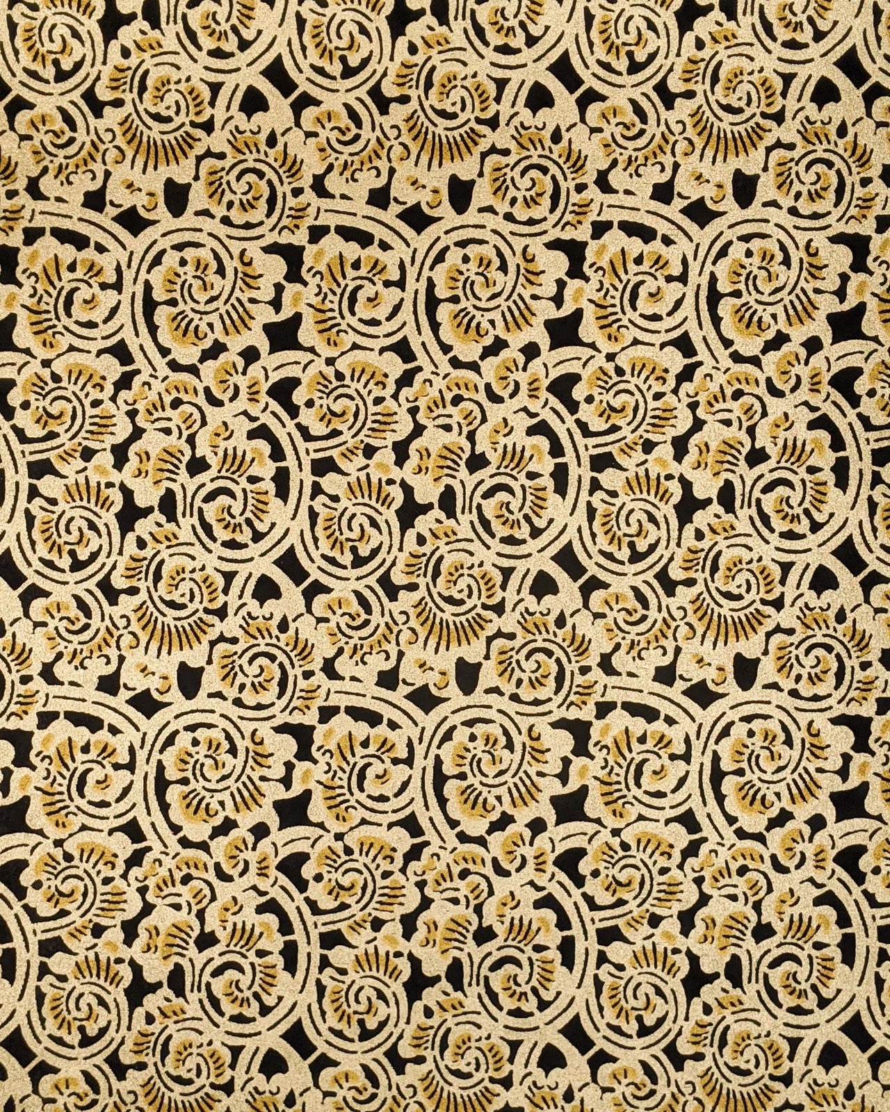 Japanese chiyogami paper featuring a large metallic gold swirl motif on a black background.
