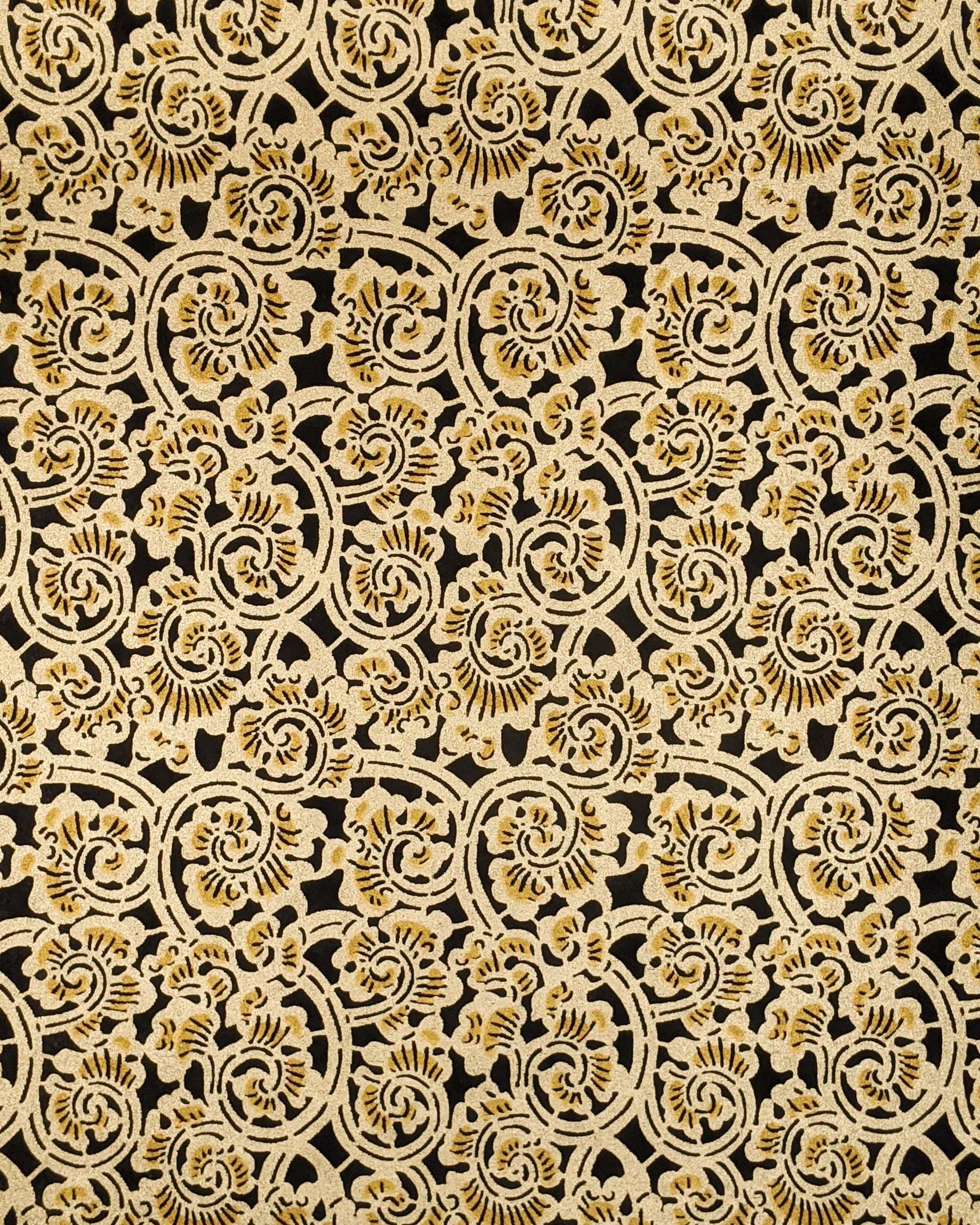 Japanese chiyogami paper featuring a large metallic gold swirl motif on a black background.