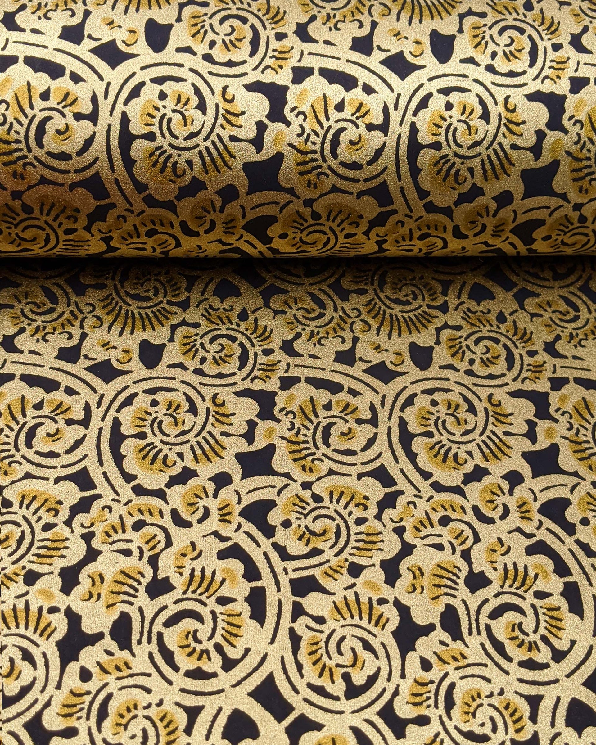 Japanese chiyogami paper featuring a large metallic gold swirl motif on a black background.