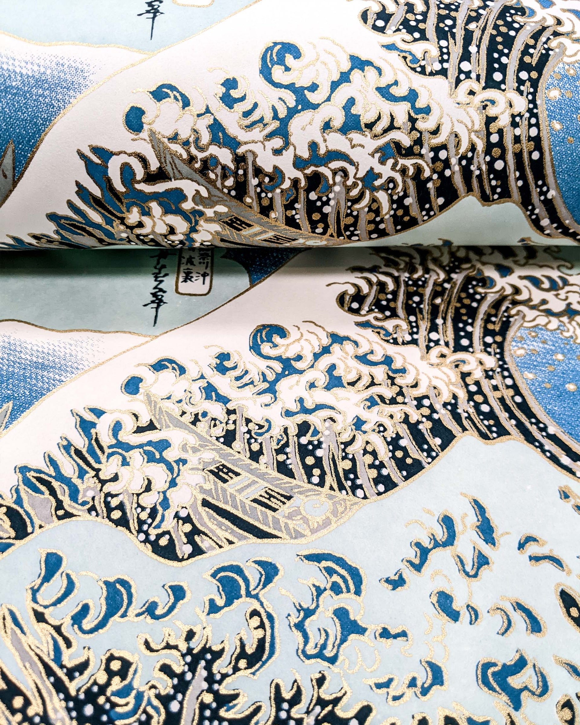 Japanese chiyogami paper featuring a bright blue version of the famous painting "The Great Wave Off Kanagawa" by Katsushika Hokusai with metallic gold details. 