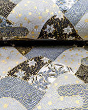 Japanese chiyogami paper featuring a black and gray hill design decorated with various Japanese flowers, maple leaves, and traditional geometric designs with metallic gold accents.