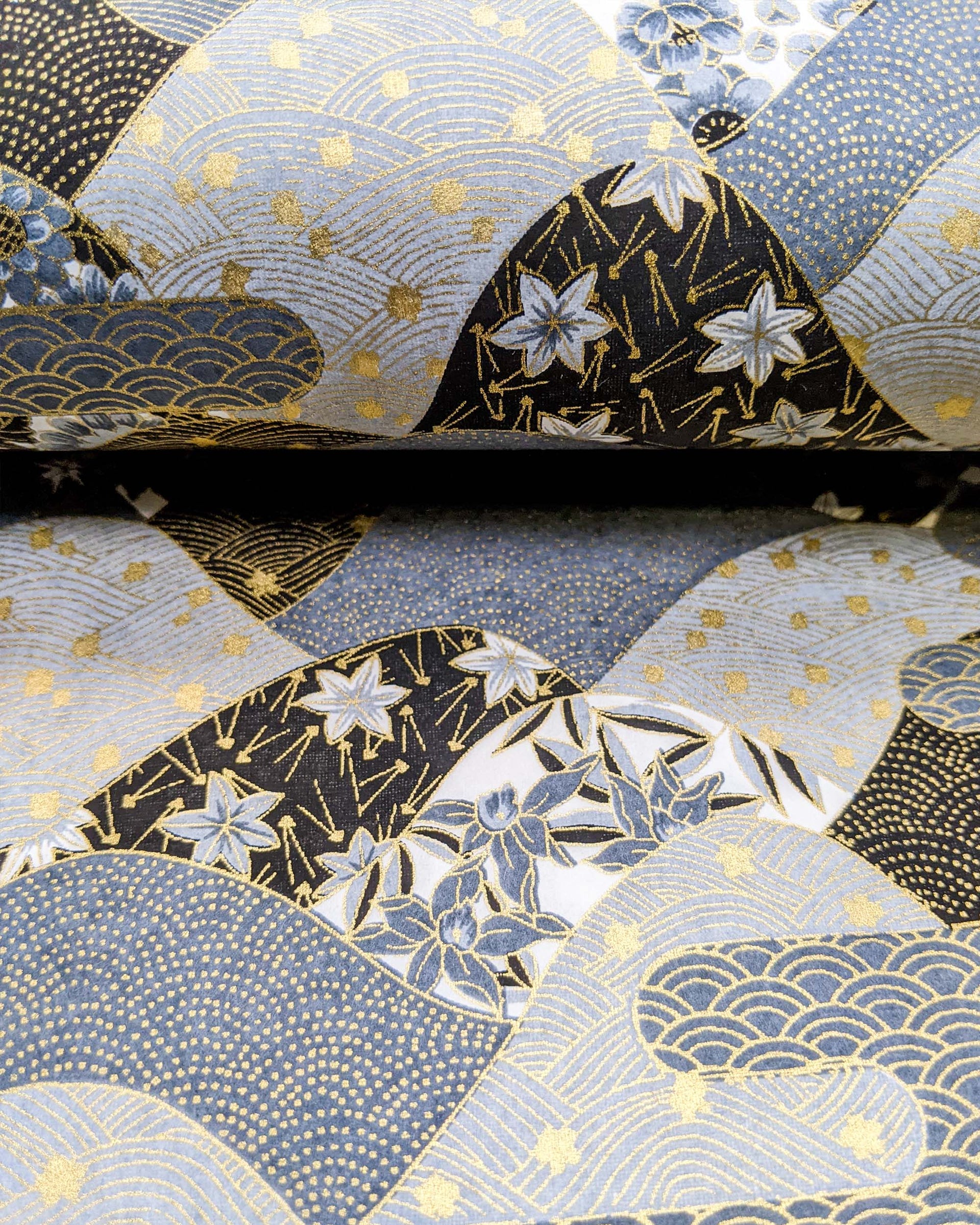 Japanese chiyogami paper featuring a black and gray hill design decorated with various Japanese flowers, maple leaves, and traditional geometric designs with metallic gold accents.