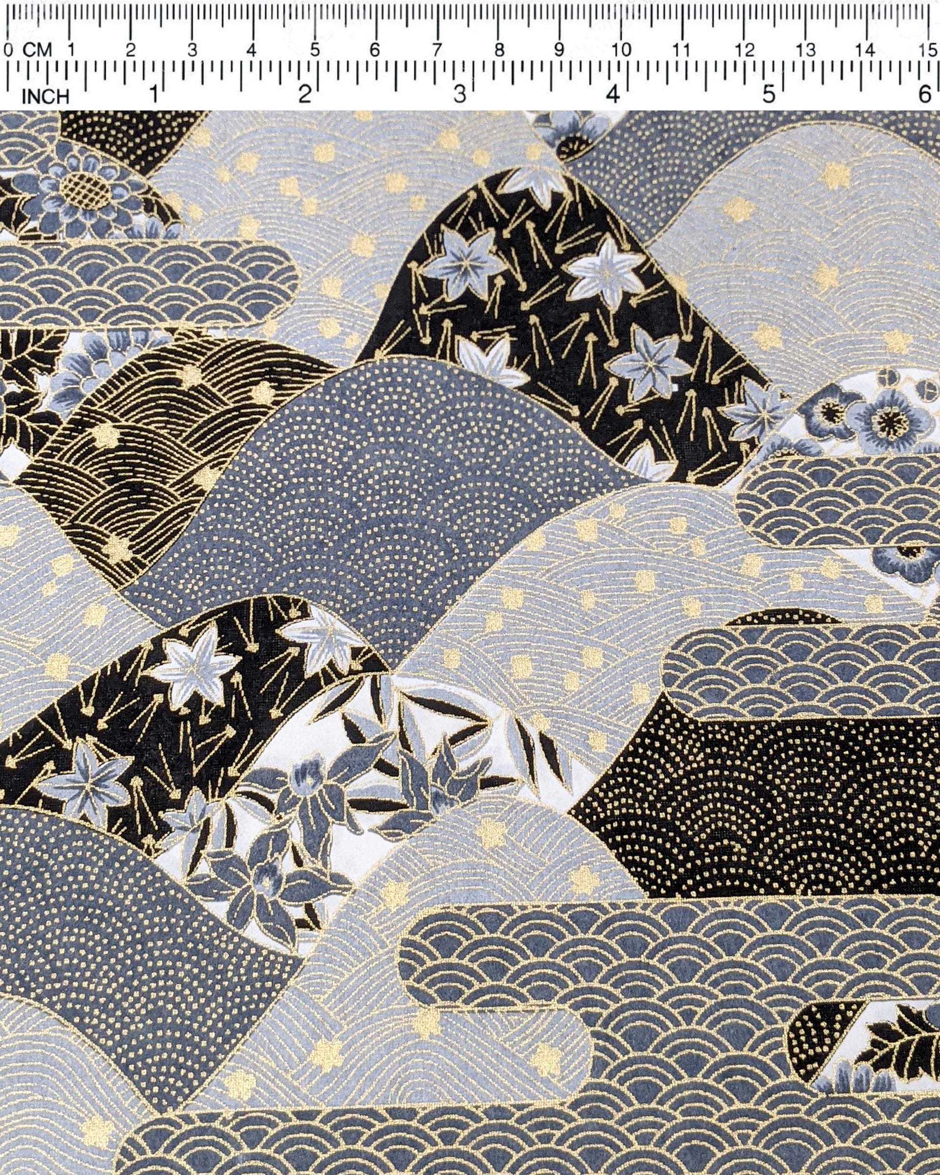 Japanese chiyogami paper featuring a black and gray hill design decorated with various Japanese flowers, maple leaves, and traditional geometric designs with metallic gold accents.