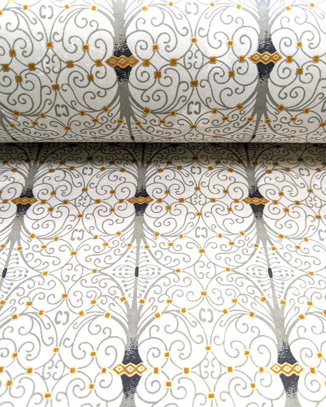 Japanese chiyogami paper featuring a gray wrought iron design on a light gray background with metallic gold details.