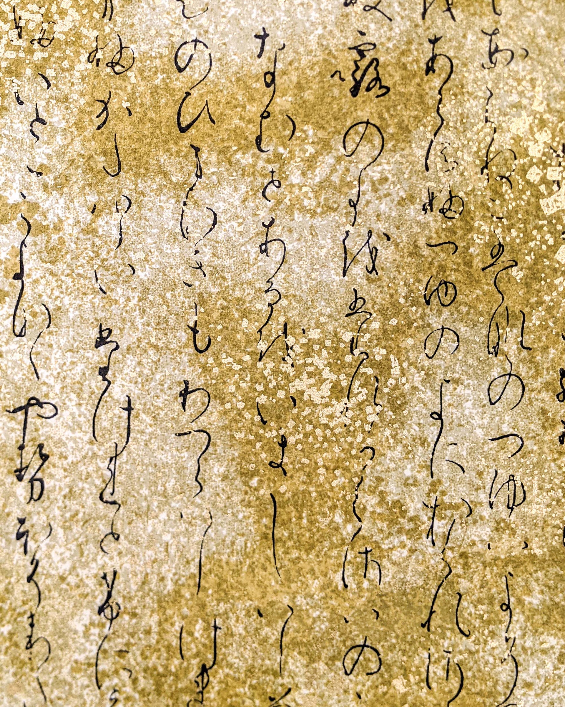 Japanese chiyogami paper featuring kanji calligraphy on a brown background with metallic gold details.