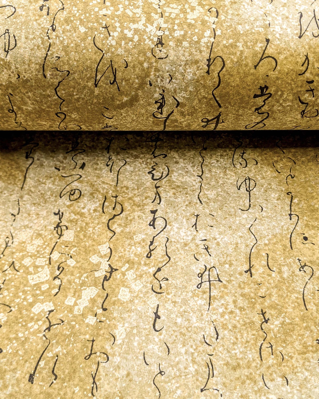 Japanese chiyogami paper featuring kanji calligraphy on a brown background with metallic gold details.