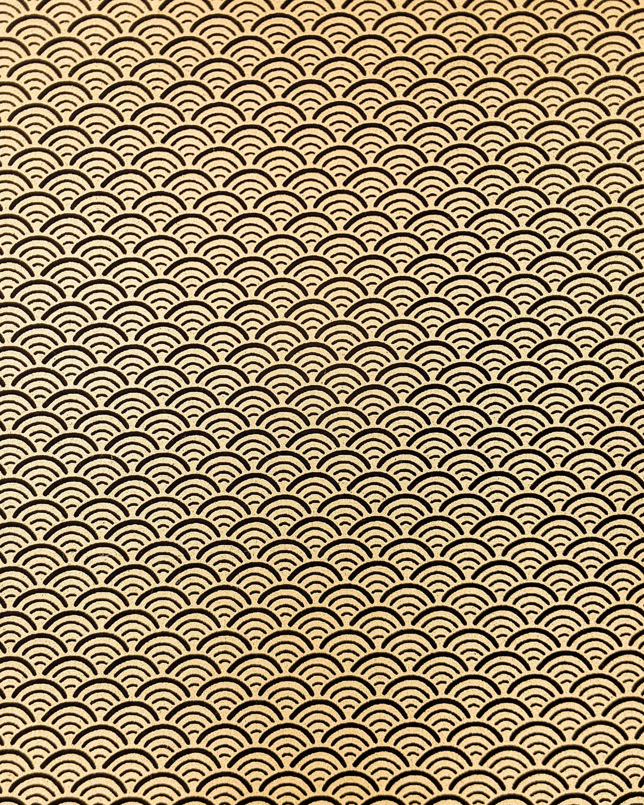 Japanese chiyogami paper featuring a traditional black and metallic gold seigaiha (wave crests) pattern.