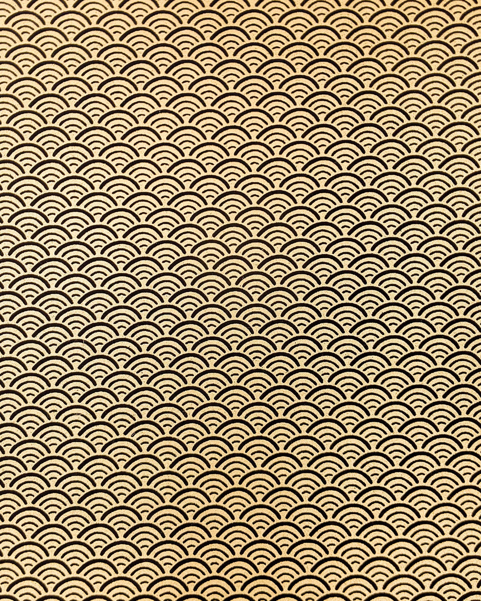 Japanese chiyogami paper featuring a traditional black and metallic gold seigaiha (wave crests) pattern.