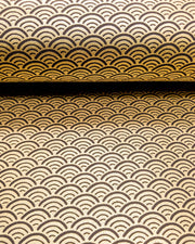 Japanese chiyogami paper featuring a traditional black and metallic gold seigaiha (wave crests) pattern.