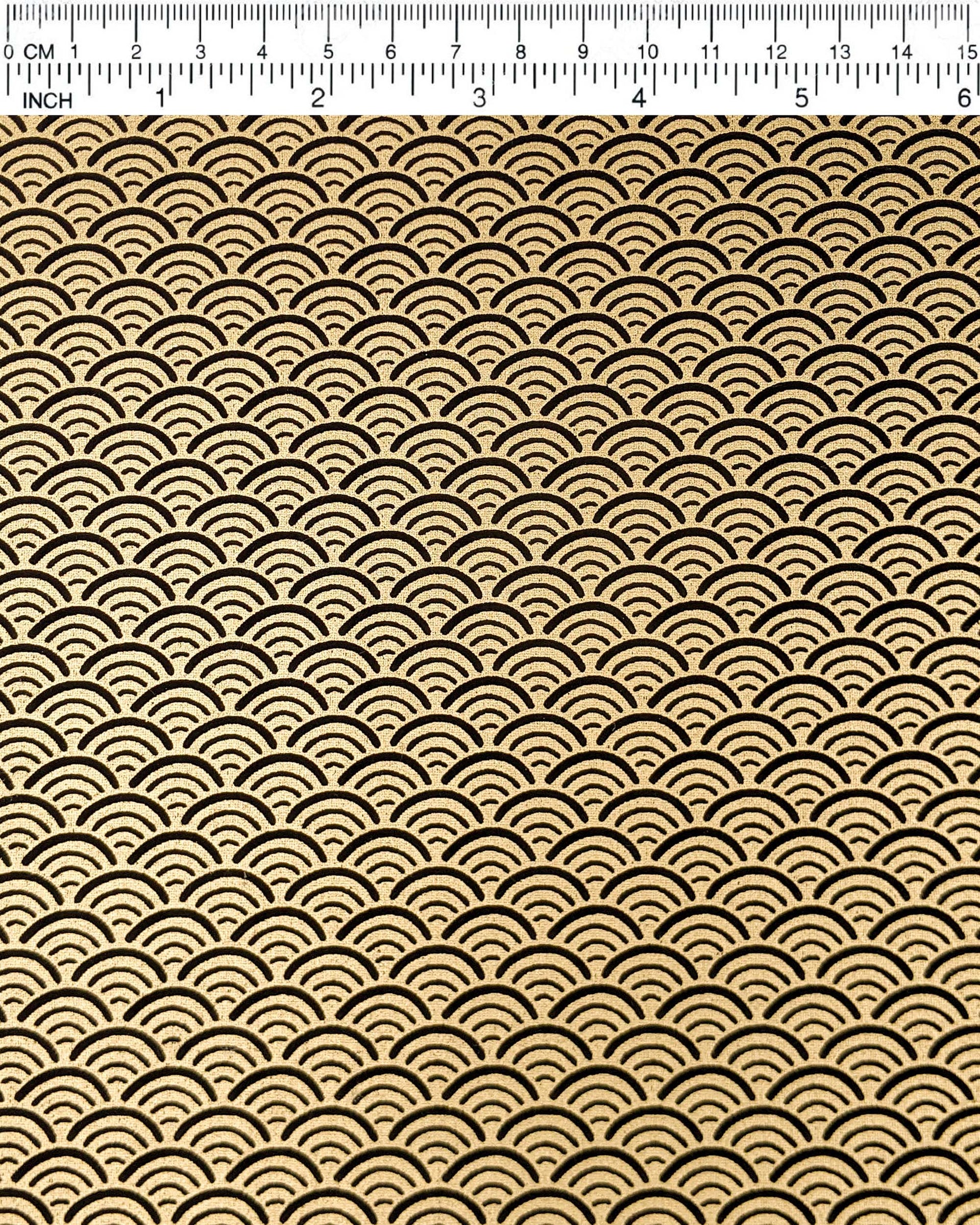 Japanese chiyogami paper featuring a traditional black and metallic gold seigaiha (wave crests) pattern.