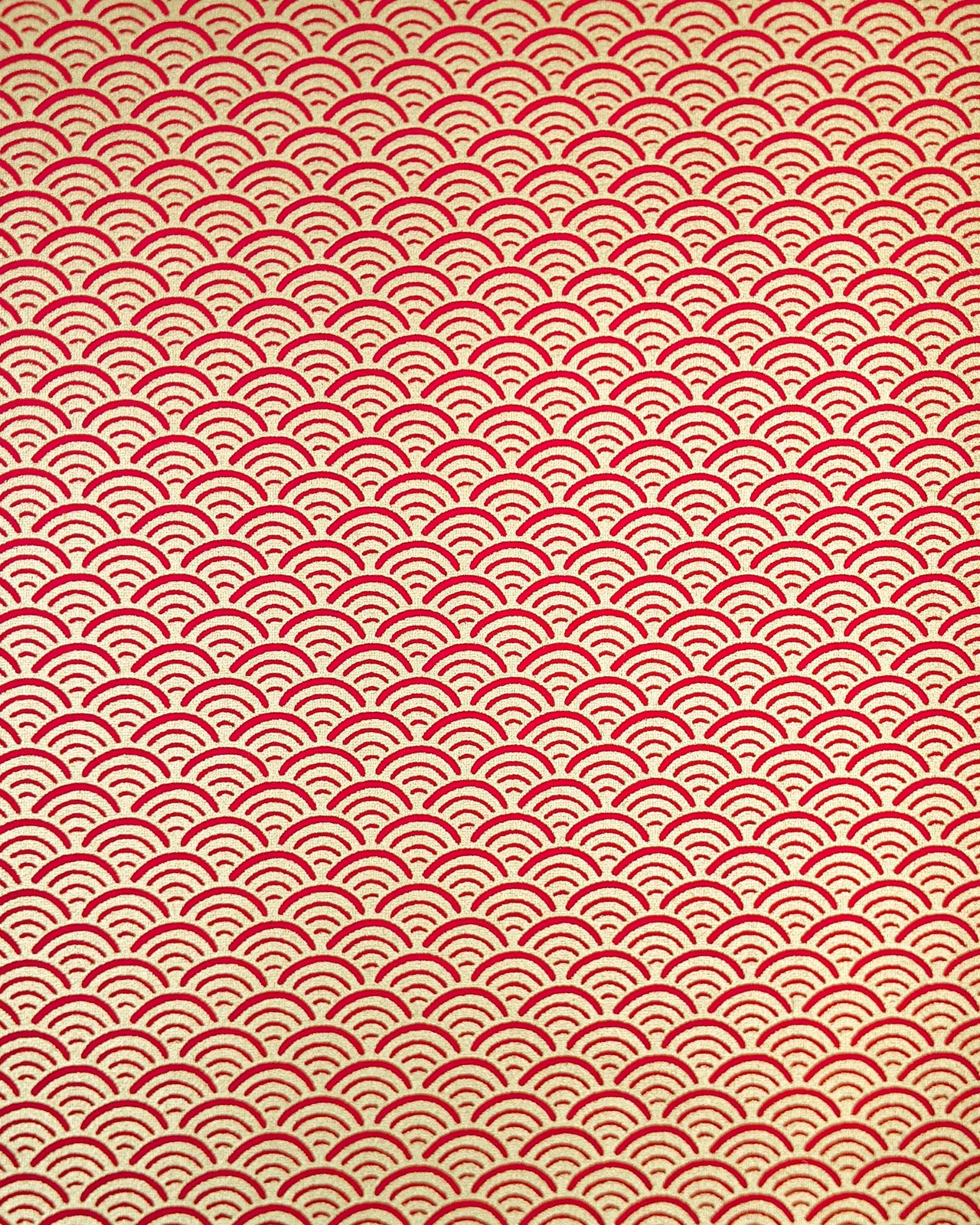 Japanese chiyogami paper featuring a traditional red and metallic gold seigaiha (wave crests) pattern.