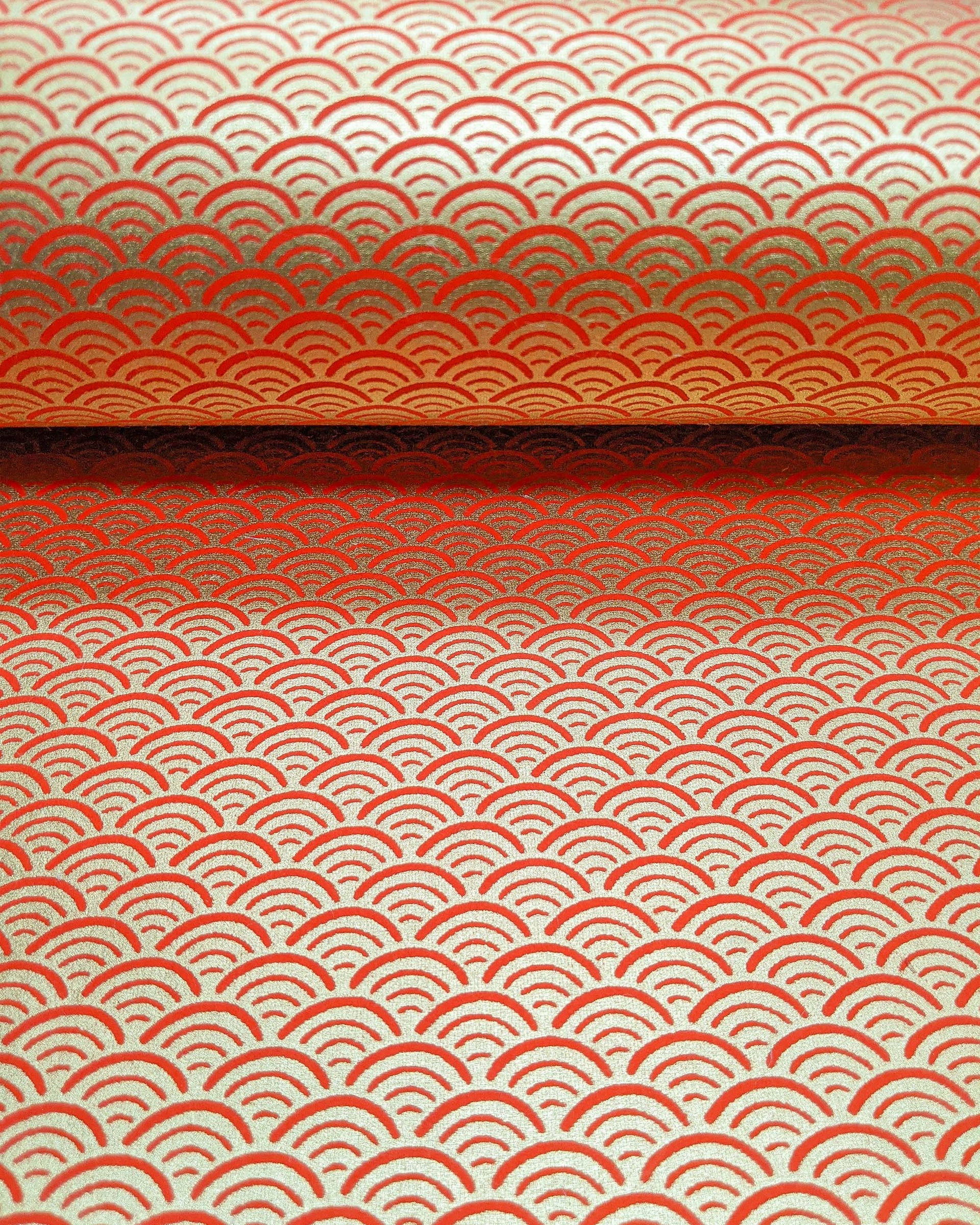 Japanese chiyogami paper featuring a traditional red and metallic gold seigaiha (wave crests) pattern.