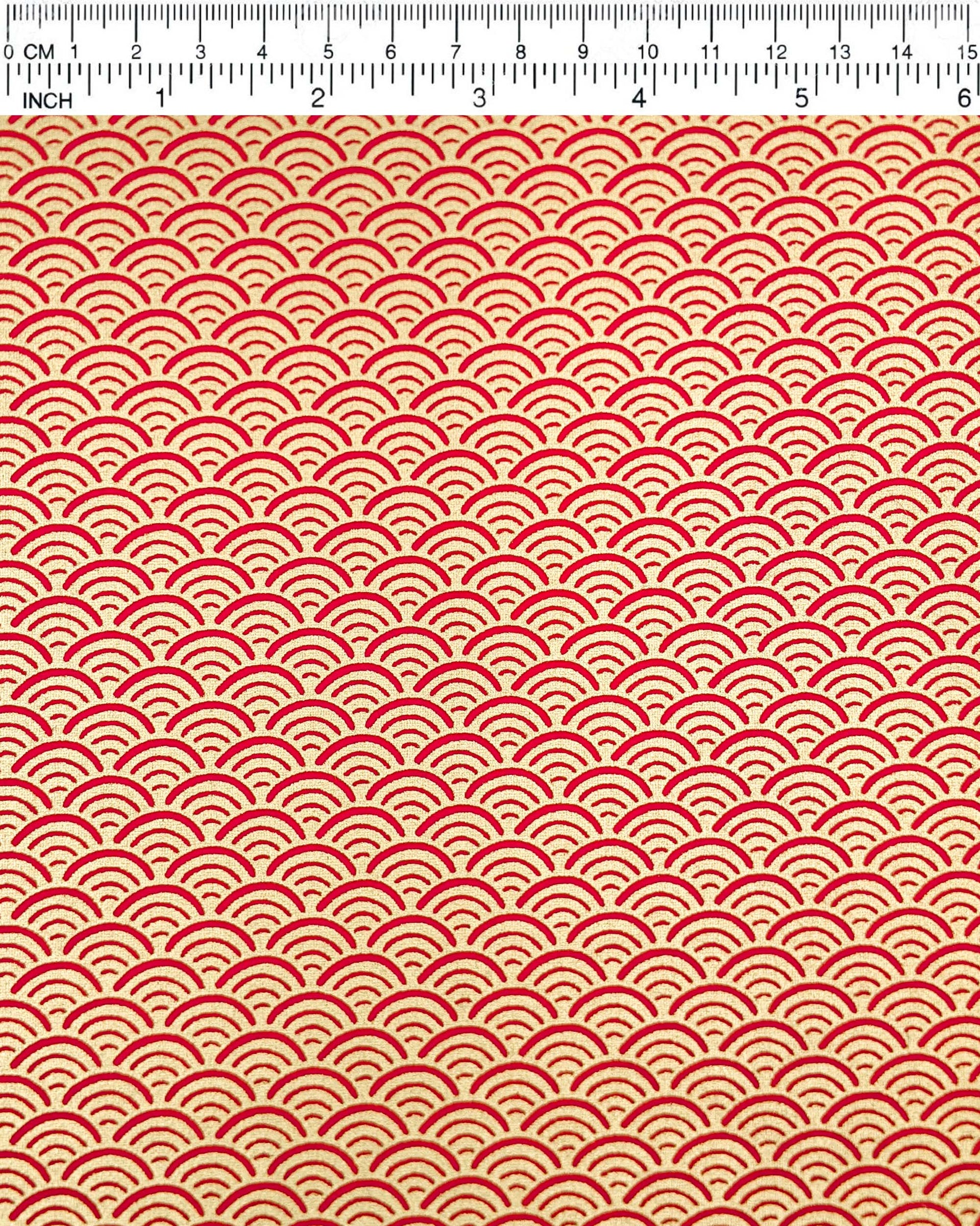 Japanese chiyogami paper featuring a traditional red and metallic gold seigaiha (wave crests) pattern.