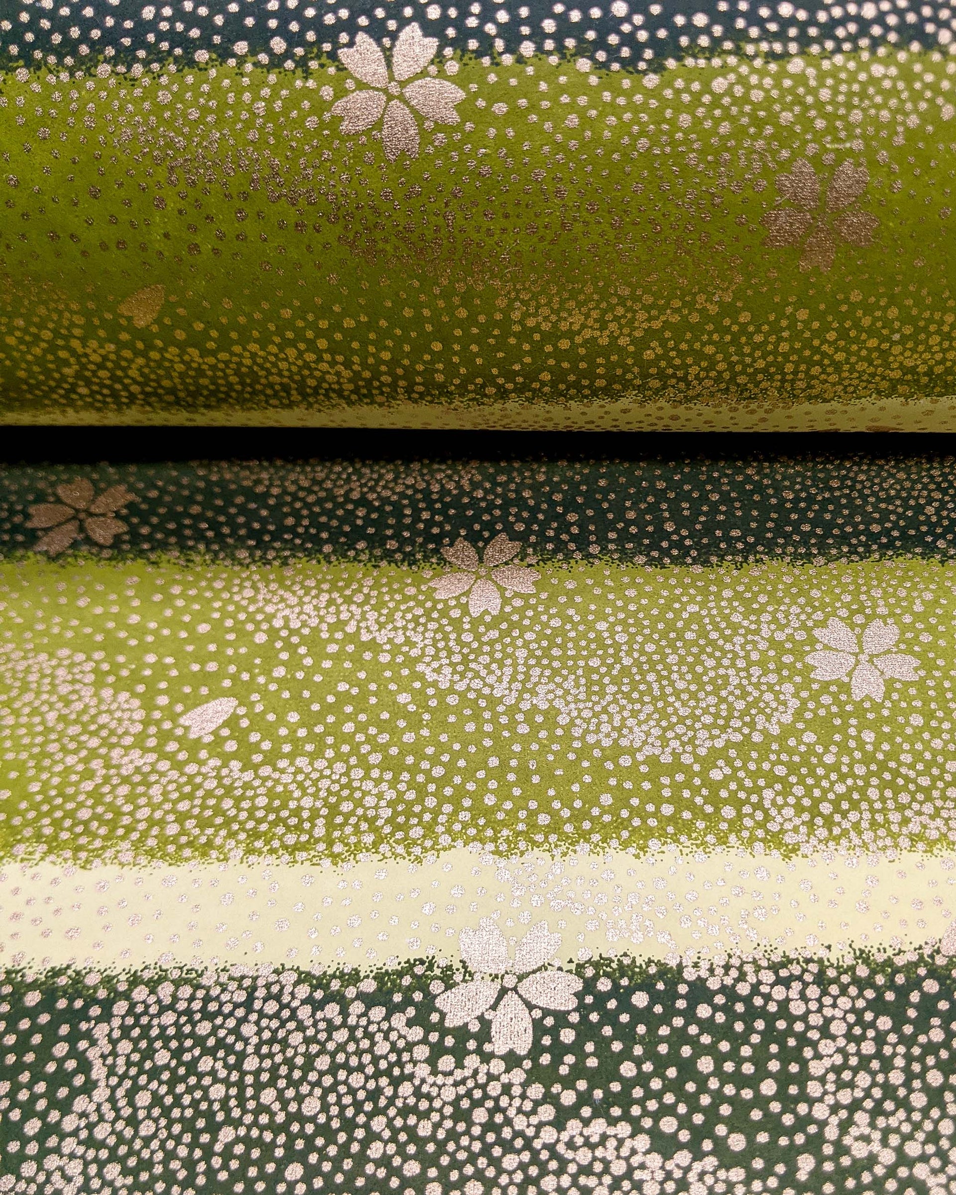 Japanese chiyogami paper featuring gold cherry blossoms on a multi-toned green striped background with metallic gold details.