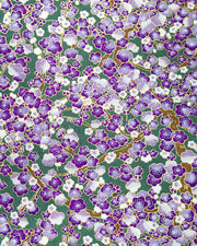 Japanese chiyogami paper featuring purple and white plum blossom trees with brown branches on a purple background with metallic gold details.
