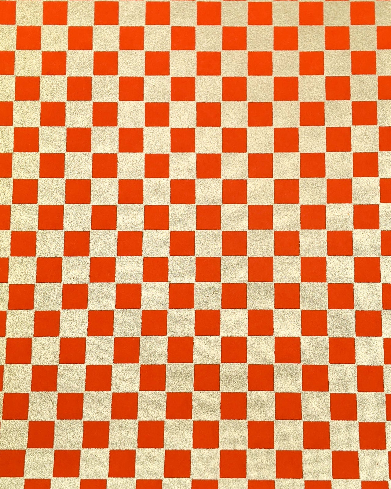 Japanese chiyogami paper featuring a traditional orange and metallic gold ichimatsu (checker) pattern.
