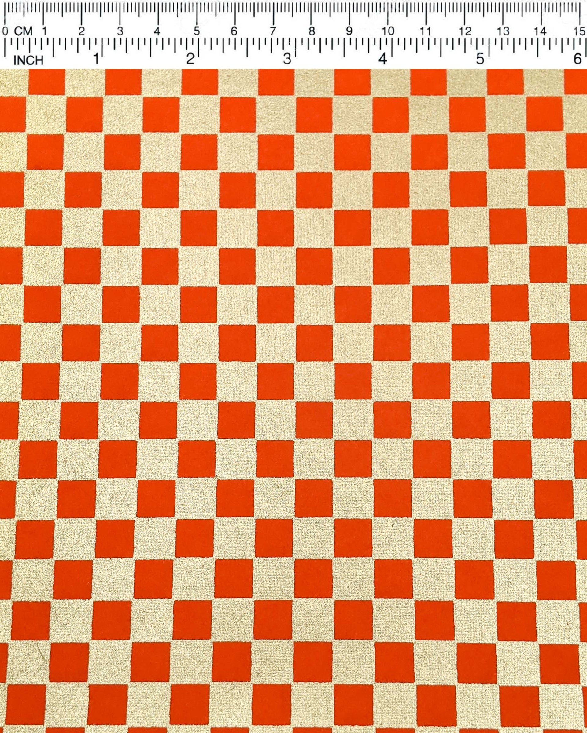 Japanese chiyogami paper featuring a traditional orange and metallic gold ichimatsu (checker) pattern.