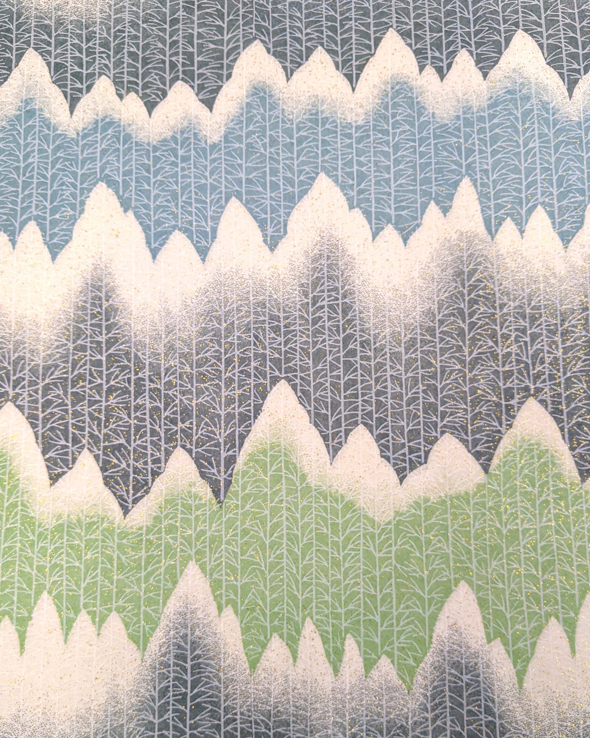 Japanese chiyogami paper featuring white snow-capped mountains with a forest of trees on a gray, blue, and green background with metallic gold glitter details.