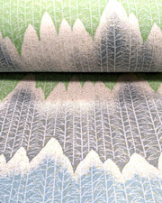 Japanese chiyogami paper featuring white snow-capped mountains with a forest of trees on a gray, blue, and green background with metallic gold glitter details.