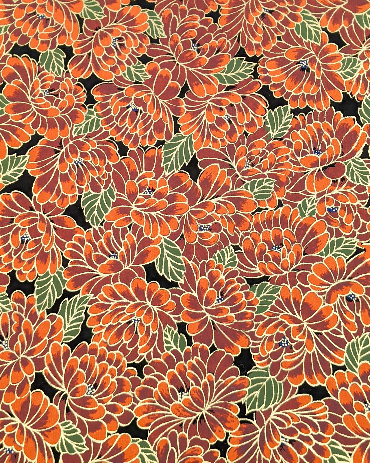 Japanese chiyogami paper featuring large red chrysanthemums with green leaves on a black background with metallic gold details.