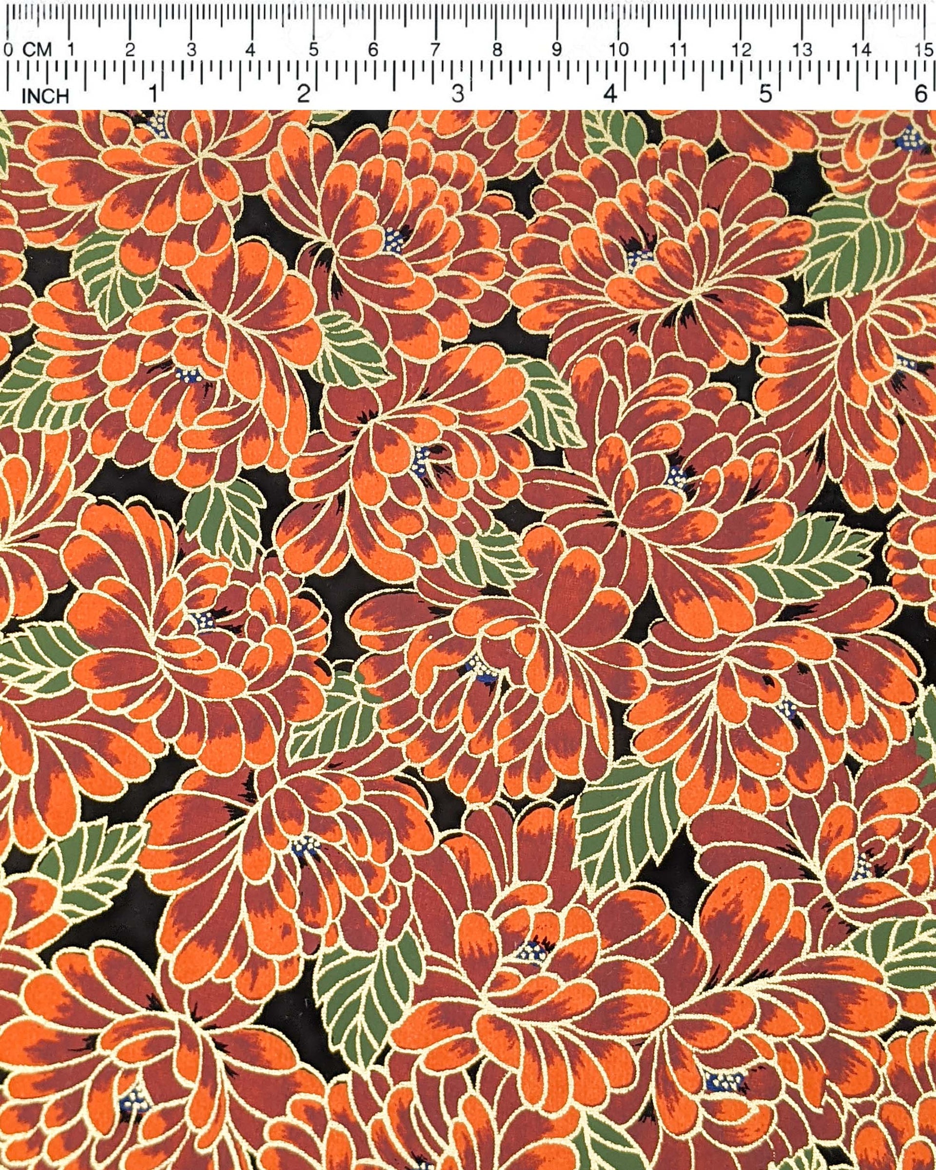 Japanese chiyogami paper featuring large red chrysanthemums with green leaves on a black background with metallic gold details.