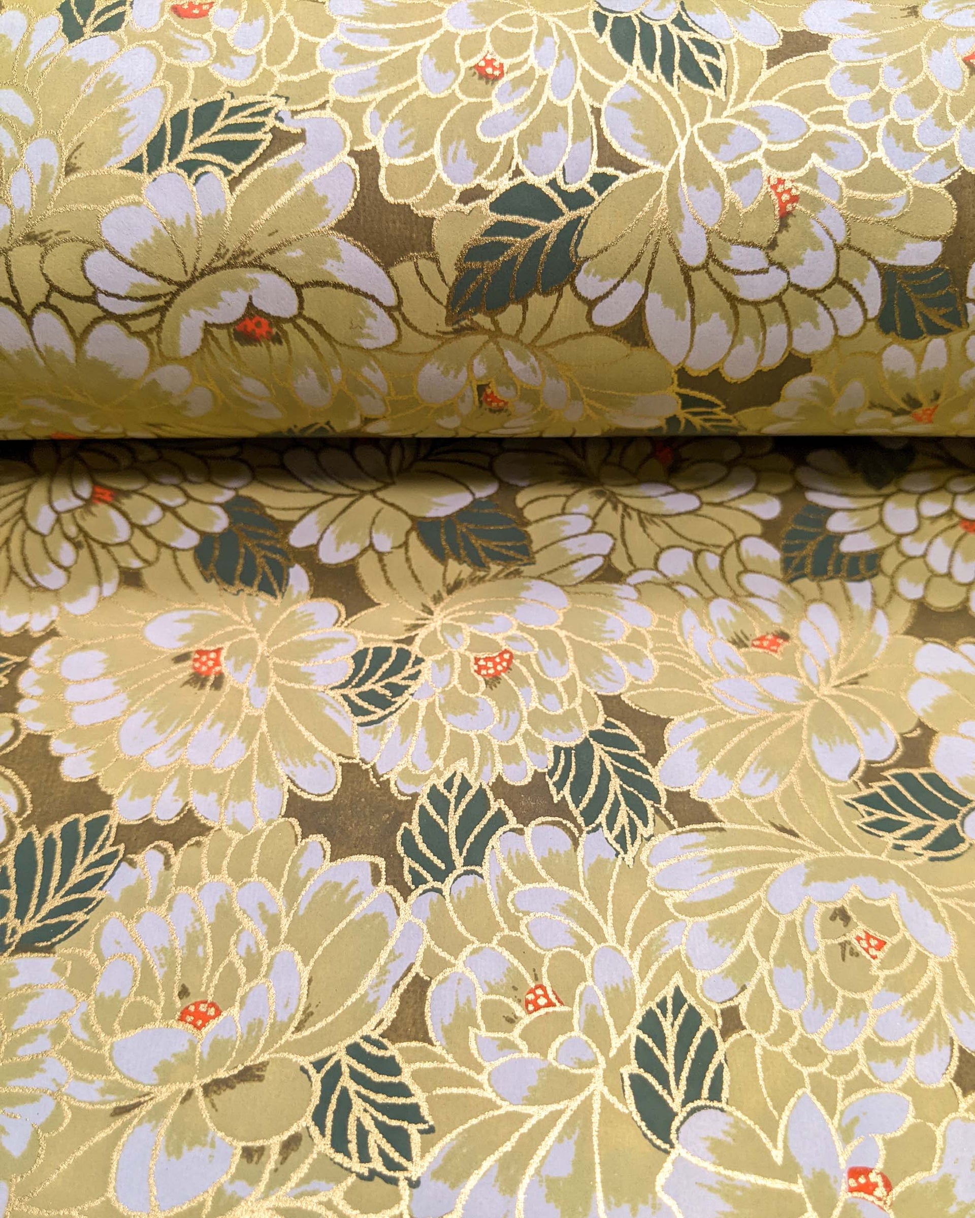 Japanese chiyogami paper featuring large yellow chrysanthemums with green leaves on a brown background with metallic gold details.