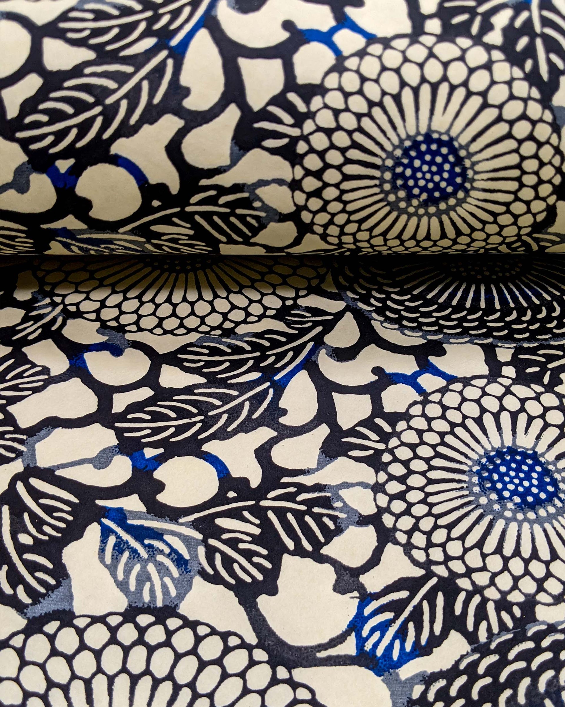 Japanese chiyogami paper featuring large black and gray zinnia flowers with small blue details on a cream background.