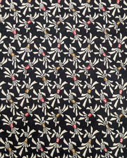 Japanese chiyogami paper featuring cream colored Japanese noshi ribbons with red and brown centers on a black background.