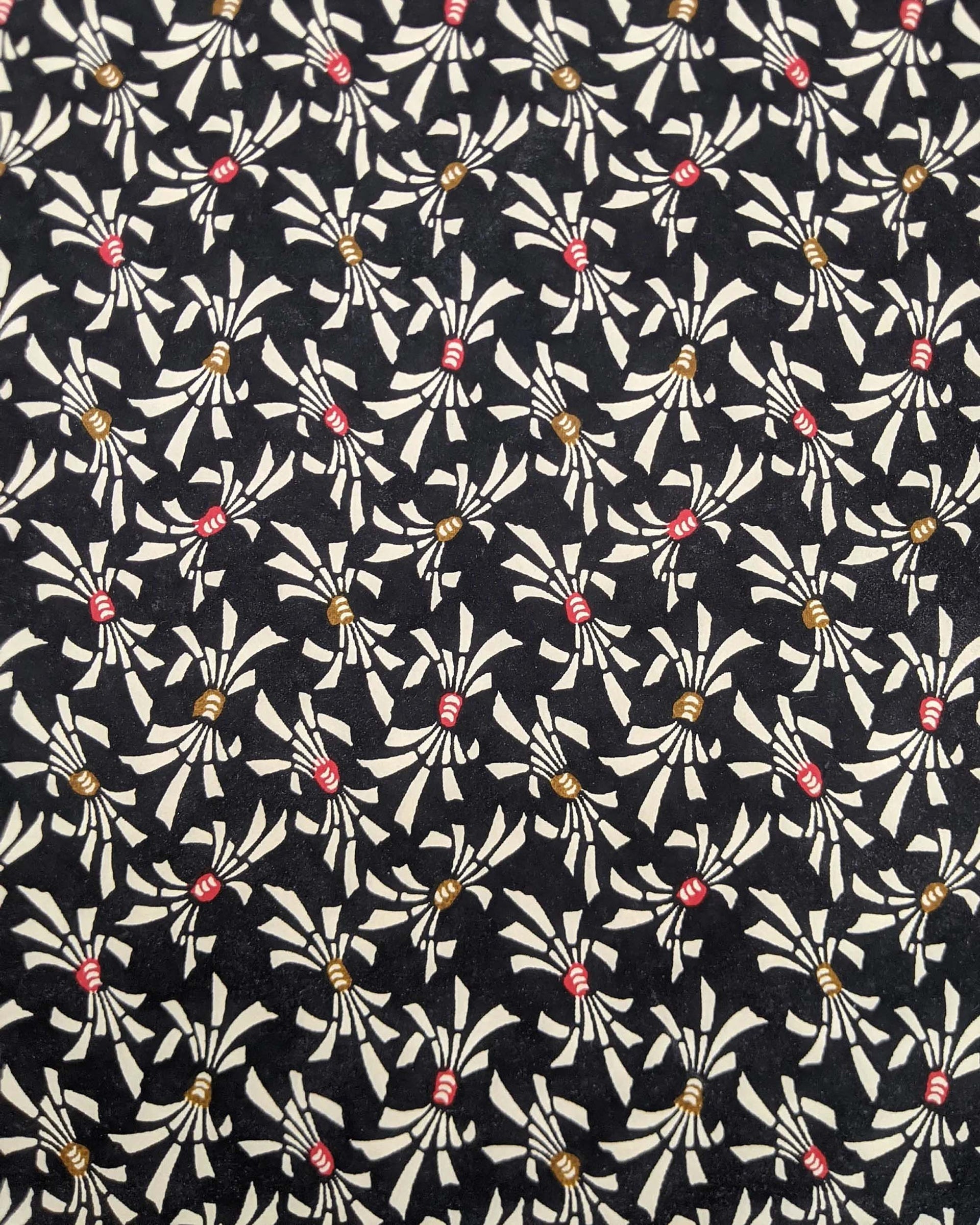 Japanese chiyogami paper featuring cream colored Japanese noshi ribbons with red and brown centers on a black background.
