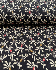 Japanese chiyogami paper featuring cream colored Japanese noshi ribbons with red and brown centers on a black background.