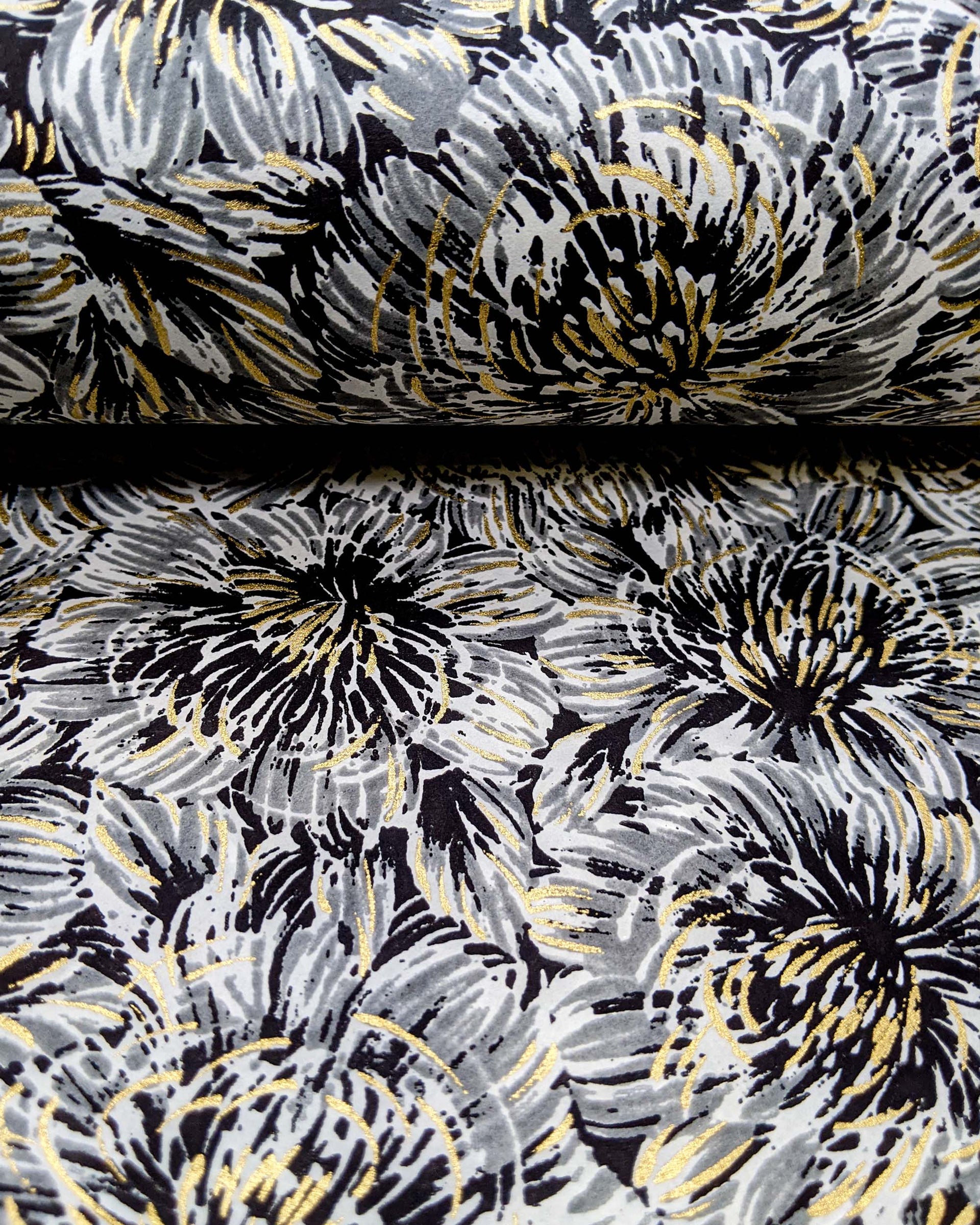 Japanese chiyogami paper featuring large black and gray chrysanthemums on a black background with metallic gold details.