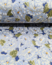 Japanese chiyogami paper featuring large light blue chrysanthemums with green leaves on a dark blue background with metallic gold details.