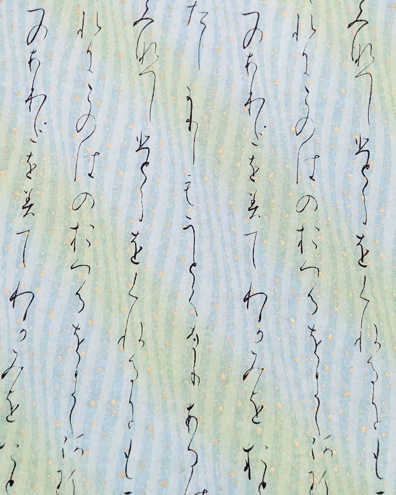 Japanese chiyogami paper featuring black Japanese calligraphy on a light turquoise background with metallic gold details.